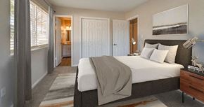 Newport News apartment for rent - A bedroom with a large bed and a painting on the wall.