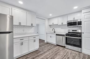 Hampton apartment for rent - A modern kitchen with white cabinets and stainless steel appliances.