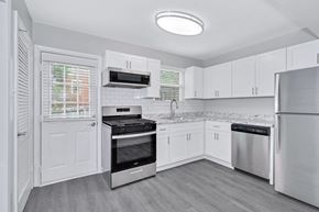 Richmond townhouse for rent - a kitchen with white cabinets and stainless steel appliances