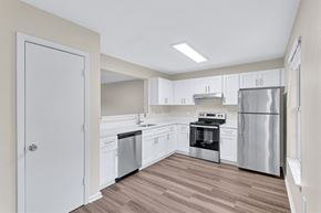 Fredericksburg townhouse for rent - A kitchen with white cabinets and stainless steel appliances.