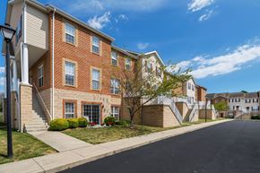 Martinsburg townhouse for rent - A row of red brick apartment buildings with green trees in front.