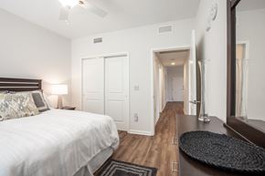 Louisville apartment for rent - Apartment bedroom furnished with bed, vanity dresser, rug, and nightstand with lamp-Beecher Terrace, Louisville, KY
