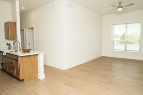 Fort Worth apartment for rent - A room with a wooden floor and a window showing trees outside.