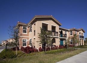 Miami apartment for rent - A beige two-story building with a balcony on the second floor.