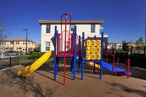 Miami apartment for rent - A playground with a yellow slide and a red and blue climbing frame.