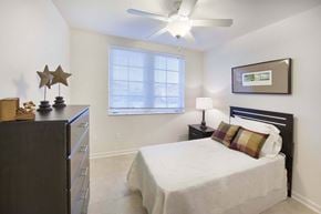 Miami apartment for rent - A bedroom with a bed, dresser, and a ceiling fan.