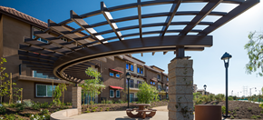 Los Angeles apartment for rent - a large building with an arch over a walkway with a bench at Rio Vista Apartments