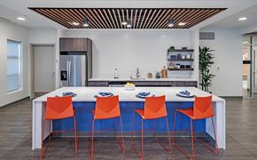 Baltimore apartment for rent - a kitchen with a blue island and four orange chairs at Perkins Square Apartments