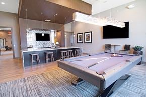 Macungie apartment for rent - A pool table is in the middle of a room with a bar and a television.