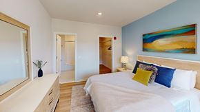 Macungie apartment for rent - A bedroom with a large bed, a dresser, and a painting on the wall.