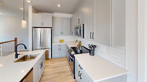 Macungie apartment for rent - A modern kitchen with white cabinets and a wooden floor.