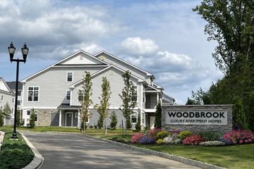 Randolph apartment for rent - A sign in front of a house that says Woodbrook Luxury Apartment Homes.