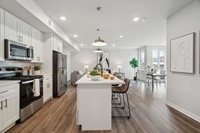 Philadelphia apartment for rent - an open kitchen and dining room with white cabinets and stainless steel appliances