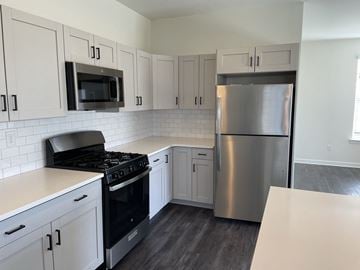 Dover apartment for rent - A kitchen with a stove, microwave, and refrigerator.