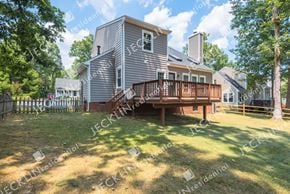 Henrico house for rent - A house with a deck and a fence in the yard.