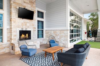 Outdoor lounge with fireplace and comfy seating
