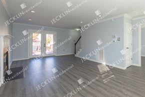 Henrico house for rent - A spacious residential room with wooden flooring and a staircase.