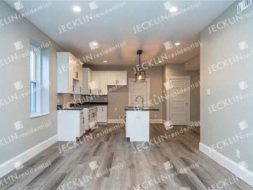 Richmond house for rent - a large kitchen with white cabinets and a sink