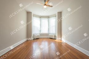 Richmond house for rent - A spacious room with wooden floors and a ceiling fan.