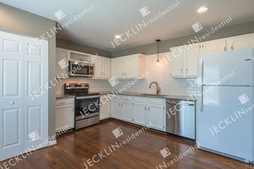 Henrico house for rent - A modern kitchen with white cabinets and stainless steel appliances.