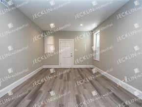 Richmond house for rent - a empty room with a white door and hardwood floors