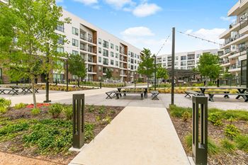 North building courtyard with grilling and picnic area, swings, fire pit with cozy seating, and yard game area