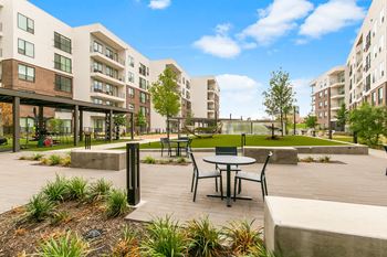 North building courtyard with grilling and picnic area, swings, fire pit with cozy seating, and yard game area