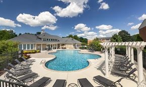 Henrico townhouse for rent - A large outdoor swimming pool surrounded by sun loungers and a covered seating area.