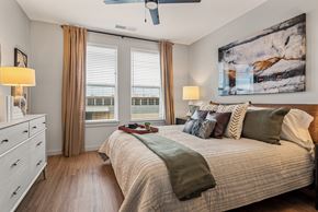 Nashville apartment for rent - A bedroom with a large bed and a ceiling fan.