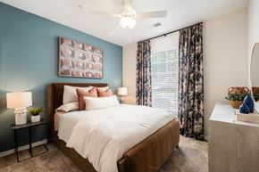 Charlotte apartment for rent - A bedroom with a large bed and a ceiling fan.