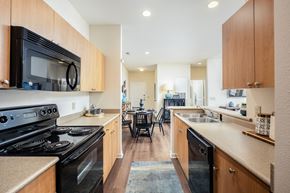Charlotte apartment for rent - A kitchen with a black stove top oven and wooden cabinets.