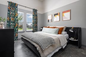 Nashville apartment for rent - a bedroom with gray walls and a black and white bed with orange and black pillows