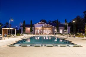 Gallatin apartment for rent - A large swimming pool in front of a building with lounge chairs around it.