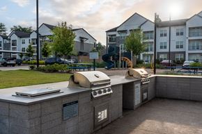 Columbia apartment for rent - A sunny day at a residential complex with a bbq grill in the foreground.