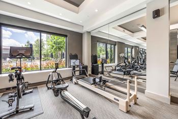 Cardio and strength training fitness center with echelon reflect mirror & bikes with on-demand classes, trx, skillmill, and pilates reformer