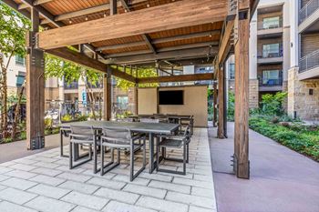 Resort-inspired pool with tanning ledge, pavilion, and outdoor kitchen