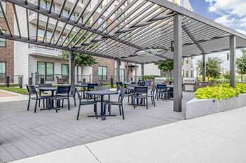 North building courtyard with grilling and picnic area, swings, fire pit with cozy seating, and yard game area
