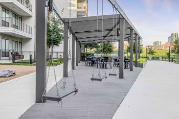 North building courtyard with grilling and picnic area, swings, fire pit with cozy seating, and yard game area
