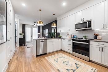 Shaker-style cabinetry with quartz countertops in kitchen and baths