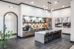 Grand Prairie apartment for rent - A modern kitchen with a bar area and a dining table set up.