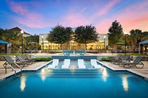 Austin apartment for rent - A large swimming pool in front of a building with lounge chairs around it.
