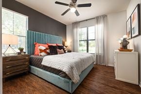 Austin apartment for rent - A bedroom with a bed, nightstand, and a ceiling fan.