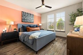 Round Rock apartment for rent - A bedroom with a bed, nightstands, and a ceiling fan.