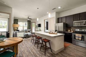 Georgetown apartment for rent - A modern kitchen with a wooden table and bar stools.