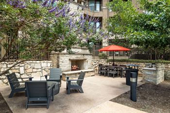 Poolside stone fireplace with cozy seating and grilling area