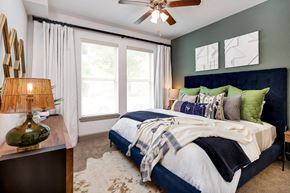 Flower Mound apartment for rent - a bedroom with a large bed and a ceiling fan