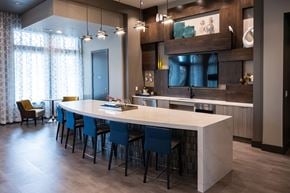 Fort Worth apartment for rent - a kitchen with a long white counter top and blue chairs