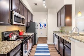 Morrisville apartment for rent - A kitchen with dark brown cabinets and granite countertops.