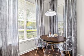 Raleigh apartment for rent - A dining room with a table set for two and a view of a backyard.