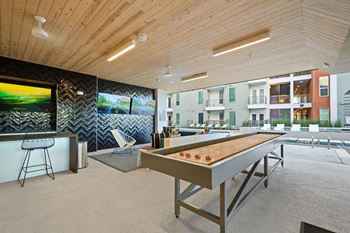 Covered poolside sports lounge with tvs and shuffleboard
